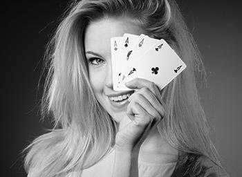 woman is holding 4 aces smiling